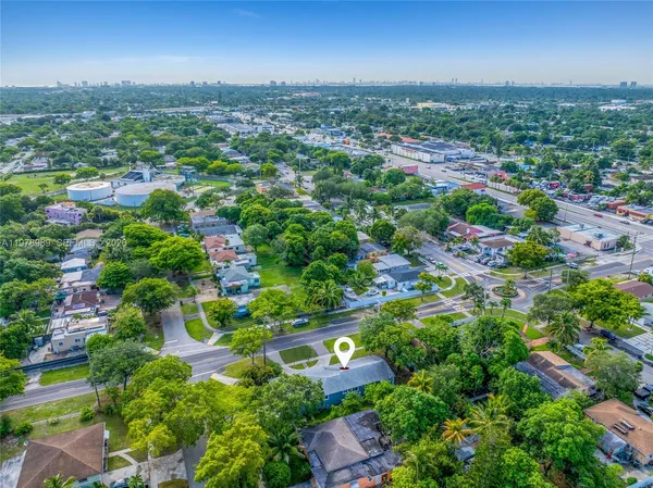 an aerial view of residential houses with outdoor space and trees