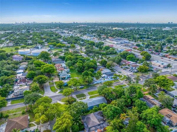an aerial view of residential houses with outdoor space and trees