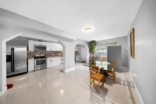 a metallic refrigerator freezer sitting in a kitchen