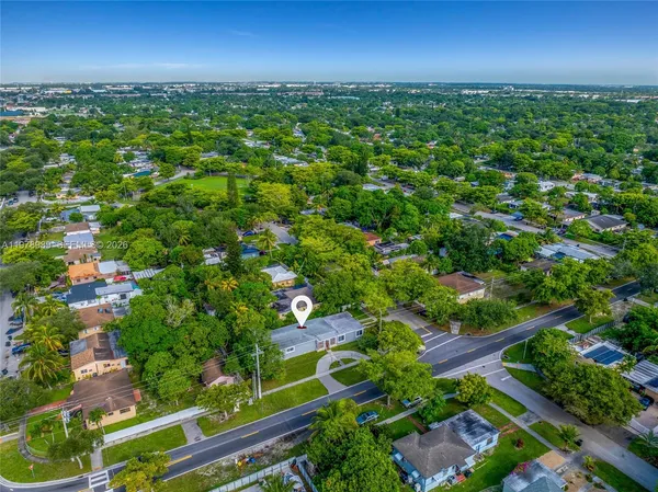 an aerial view of residential houses with outdoor space and trees