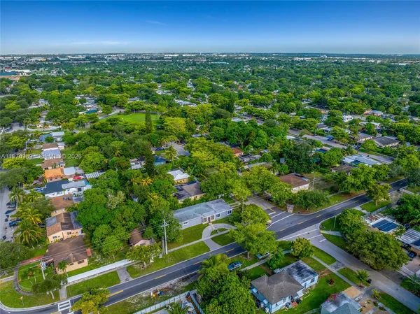 an aerial view of residential houses with outdoor space and trees