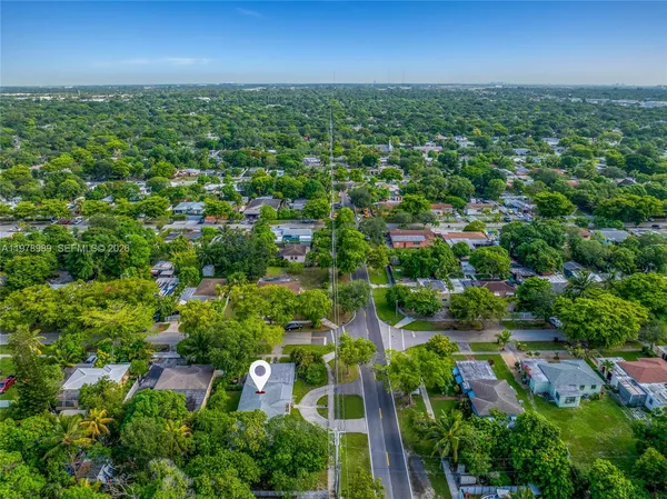 an aerial view of residential houses with outdoor space and trees