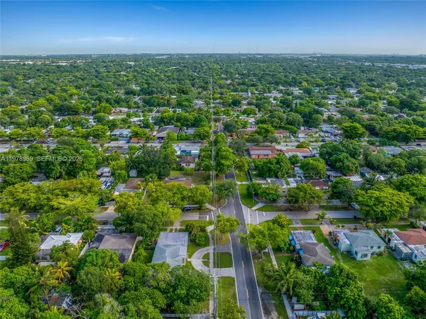 an aerial view of residential houses with outdoor space and trees