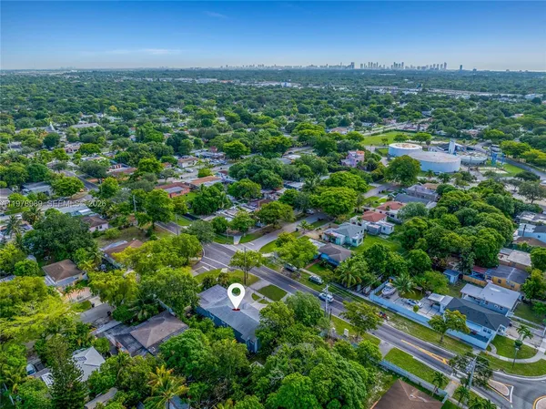 an aerial view of residential houses with outdoor space and trees