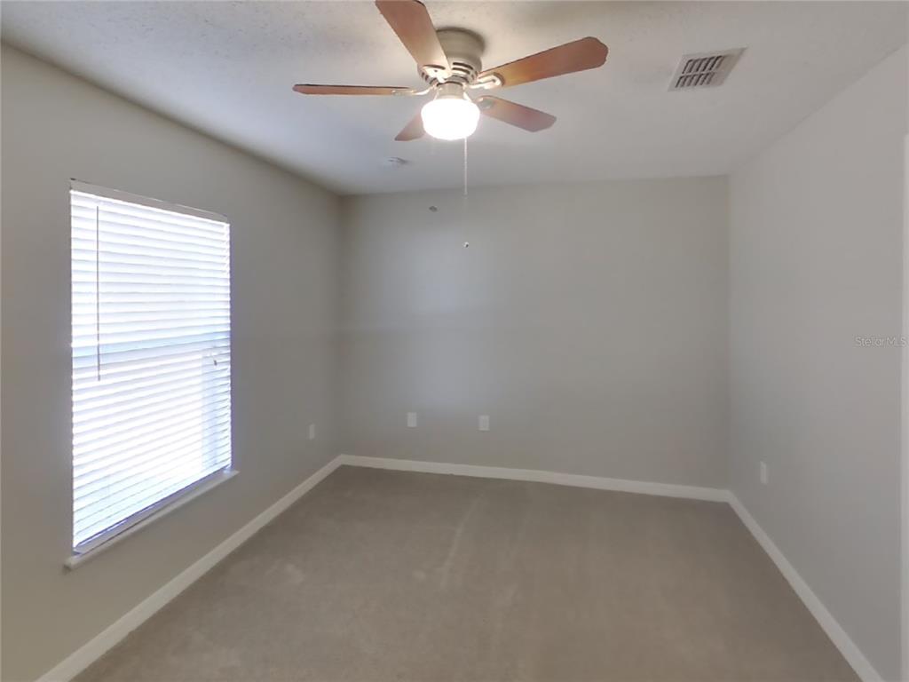 Undisclosed Address Spring Hill, FL 34609 - Photo 11 of 15 an empty room with a window and a fan