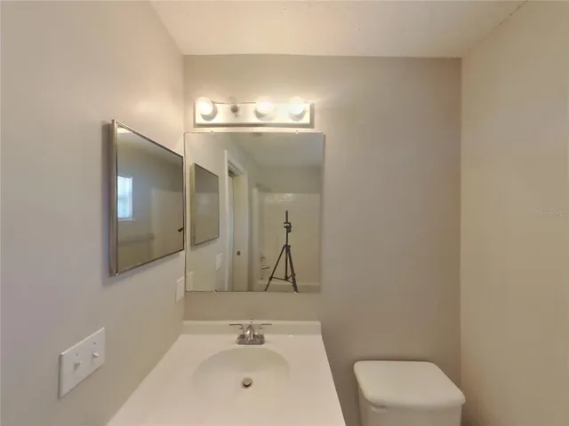 a bathroom with a sink a toilet and mirror