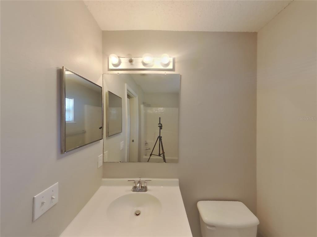Undisclosed Address Spring Hill, FL 34609 - Photo 12 of 15 a bathroom with a sink a toilet and mirror