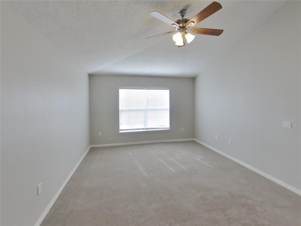 Undisclosed Address Spring Hill, FL 34609 - Photo 7 of 15 an empty room with a window and a fan