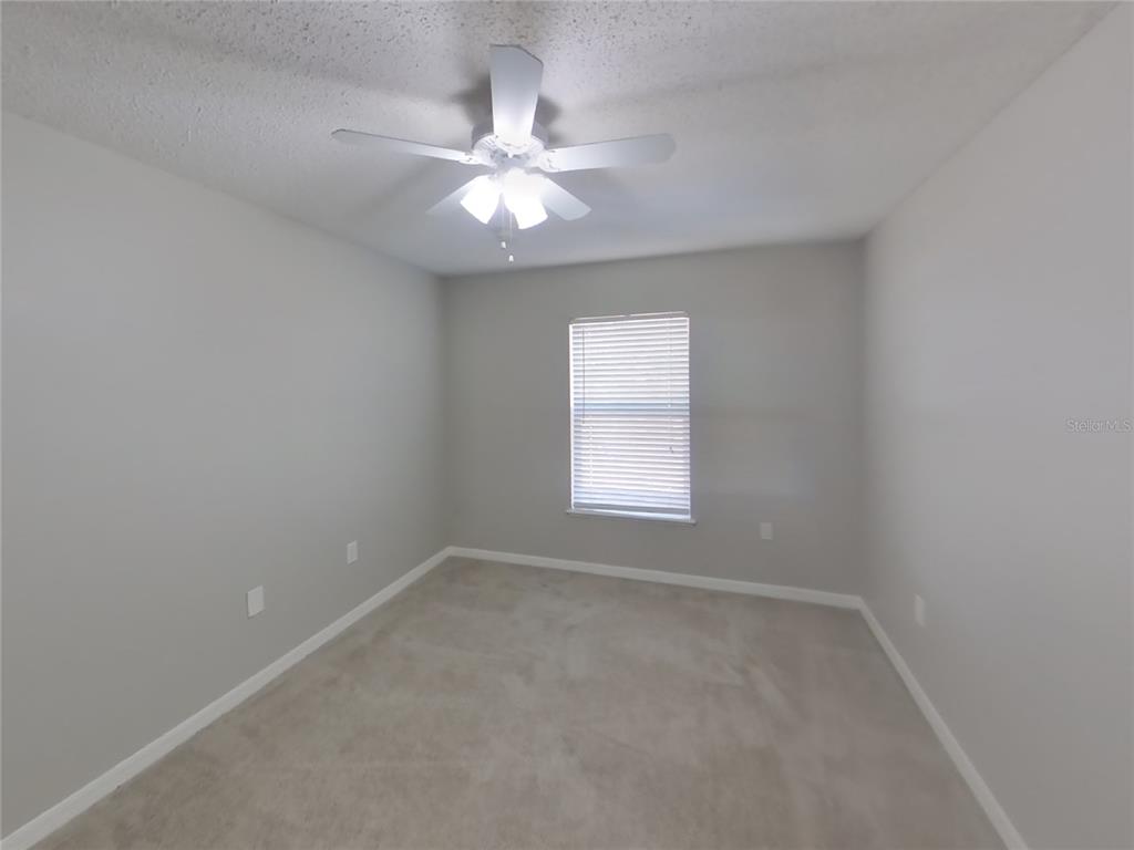 Undisclosed Address Spring Hill, FL 34609 - Photo 10 of 15 an empty room with a window and a fan