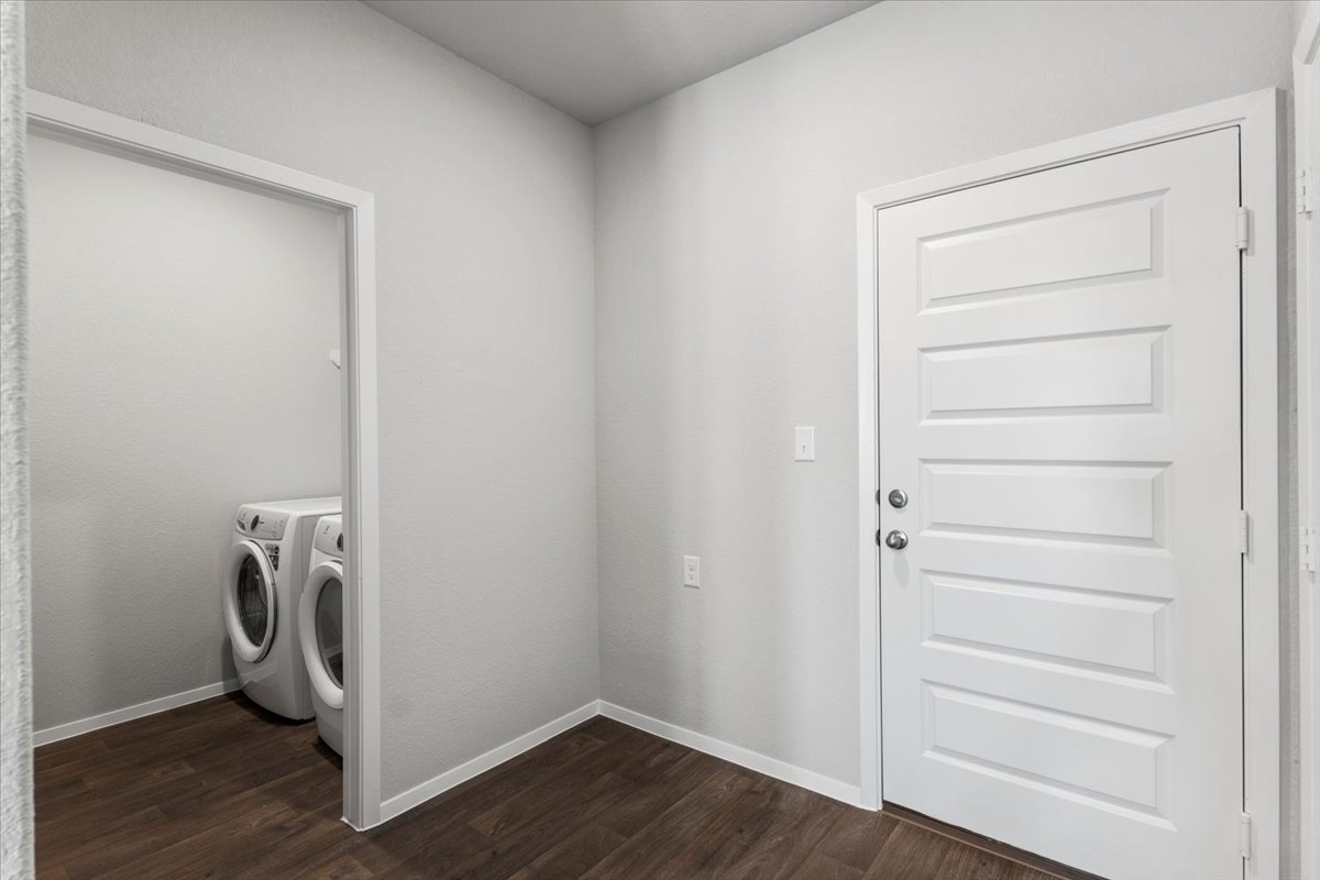 2607 Totley Road Manor, TX 78653 - Photo 13 of 40 Washroom with washer and clothes dryer and dark wood-type flooring