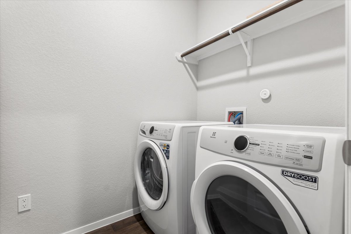 2607 Totley Road Manor, TX 78653 - Photo 14 of 40 Laundry room with washer and dryer and dark wood-style flooring