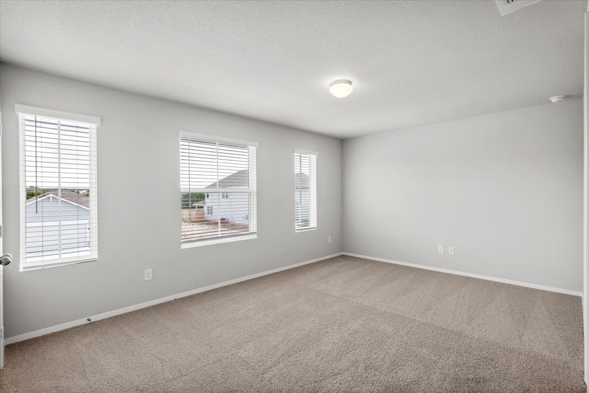 2607 Totley Road Manor, TX 78653 - Photo 23 of 40 Carpeted spare room featuring baseboards and a textured ceiling