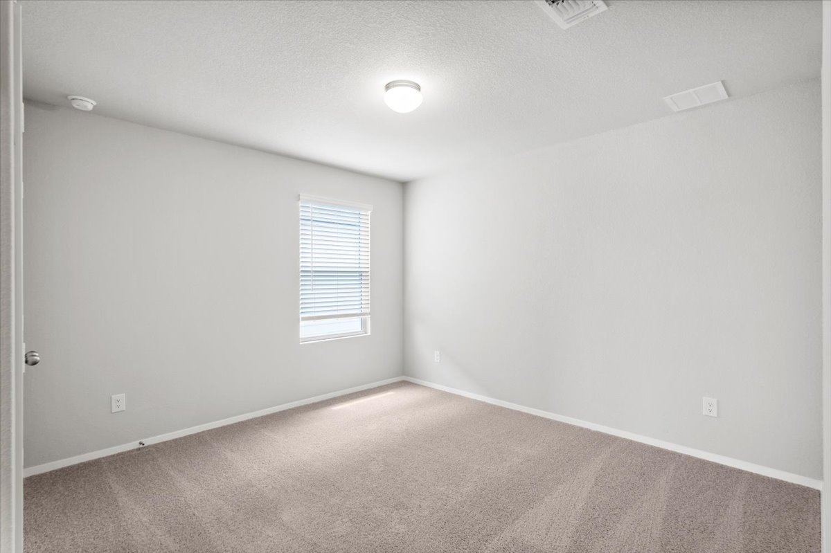 2607 Totley Road Manor, TX 78653 - Photo 27 of 40 Carpeted spare room with baseboards and a textured ceiling