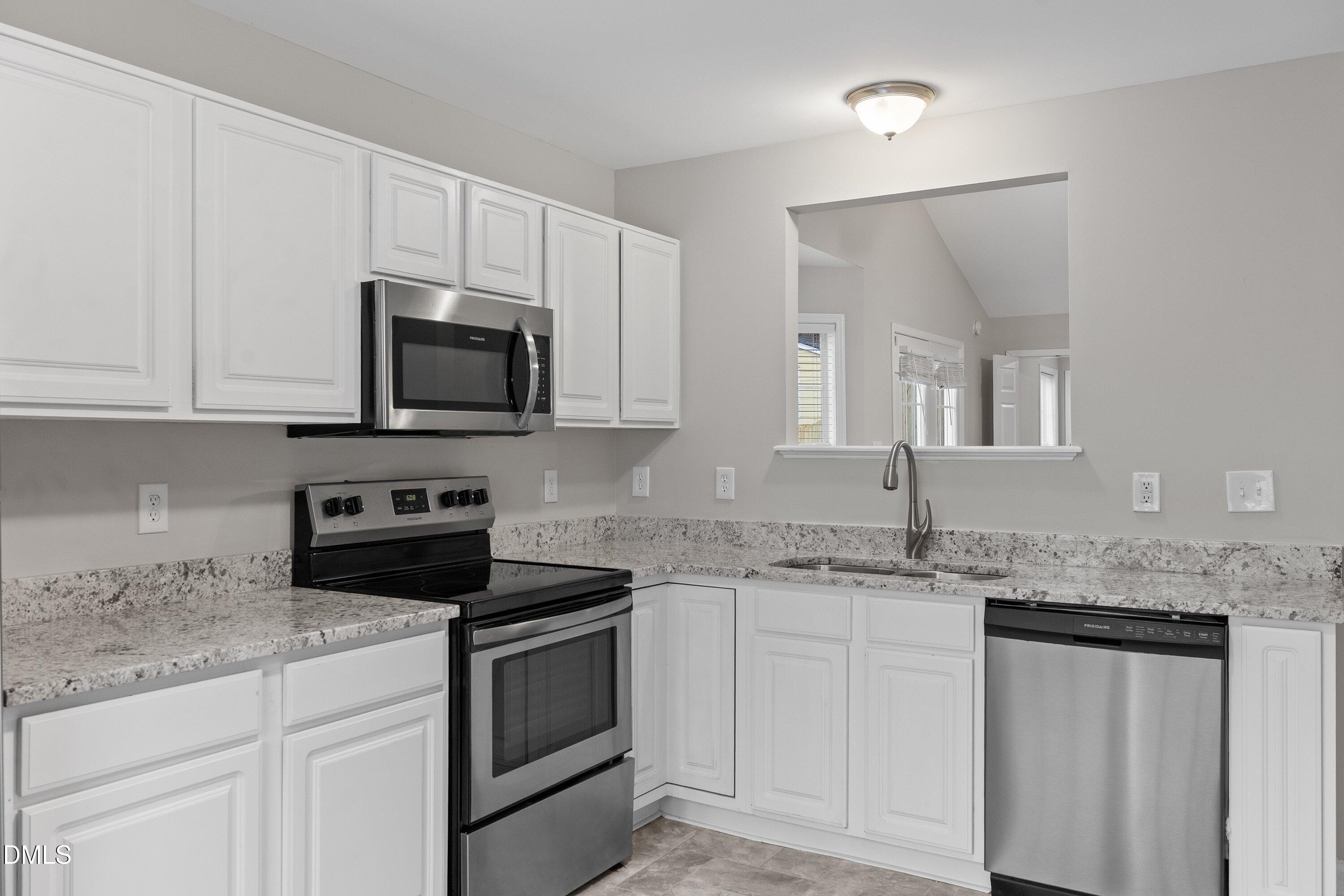 140 Melksham Road Wake Forest, NC 27587 - Photo 13 of 34 a kitchen with granite countertop white cabinets white stainless steel appliances and a sink