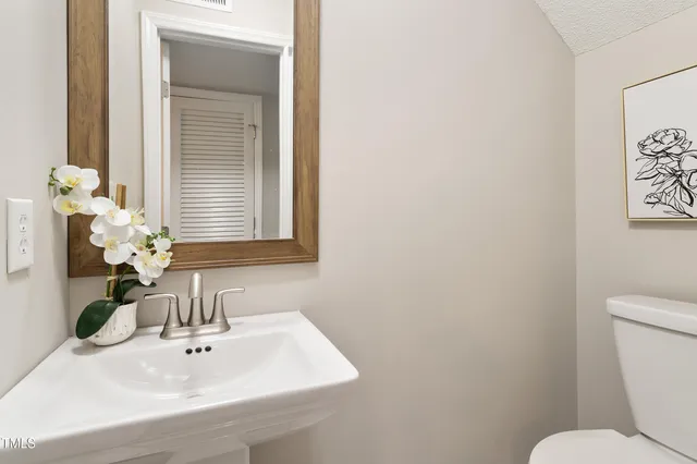 a bathroom with a sink mirror and toilet