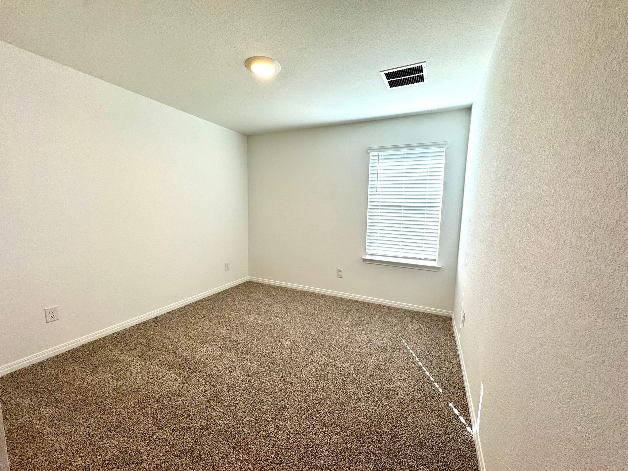 346 Gladiola Loop Kyle, TX 78640 - Photo 11 of 16 Spare room with dark carpet and baseboards