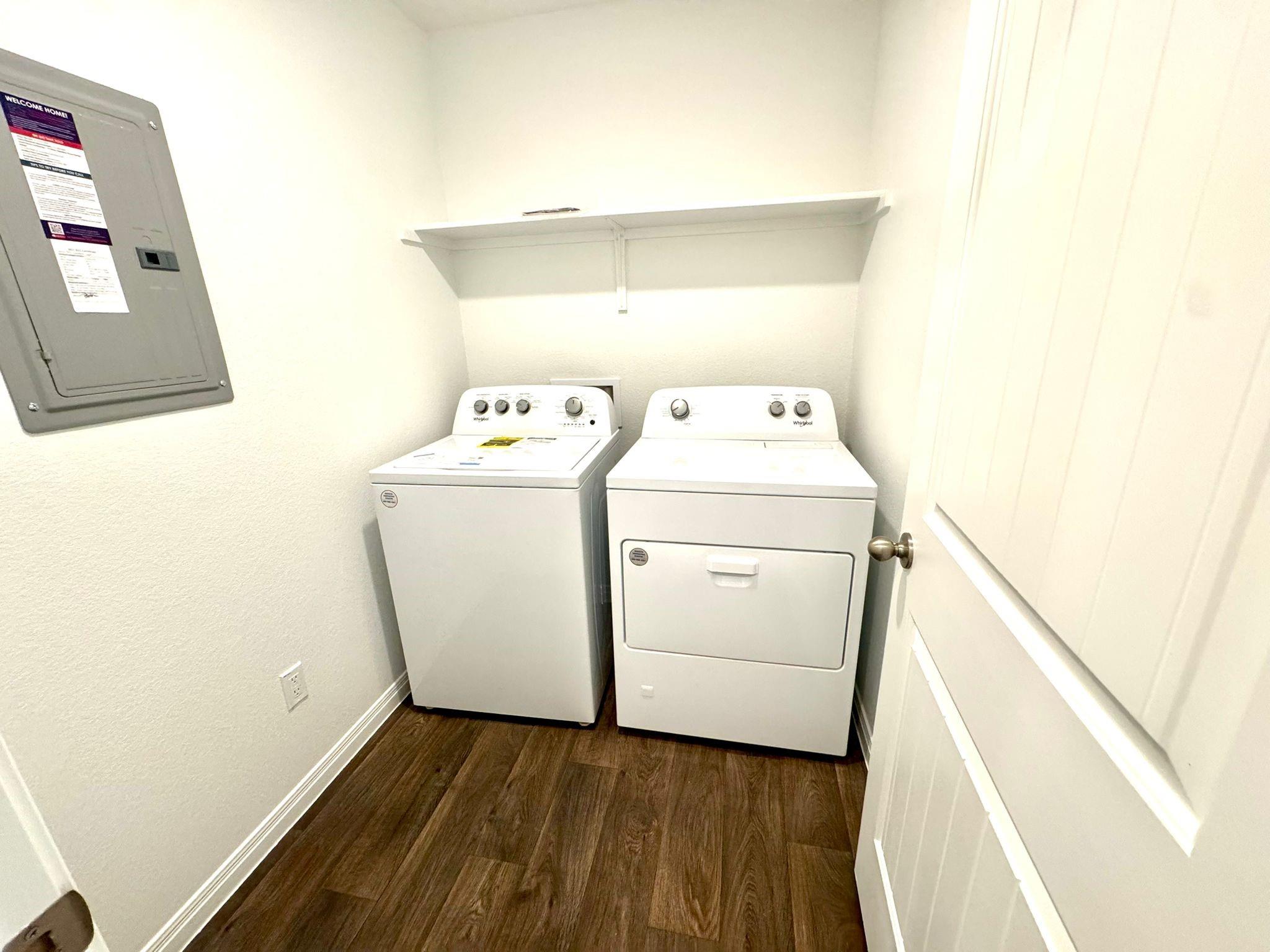 346 Gladiola Loop Kyle, TX 78640 - Photo 14 of 16 Laundry room with electric panel, dark wood-style flooring, and washing machine and dryer