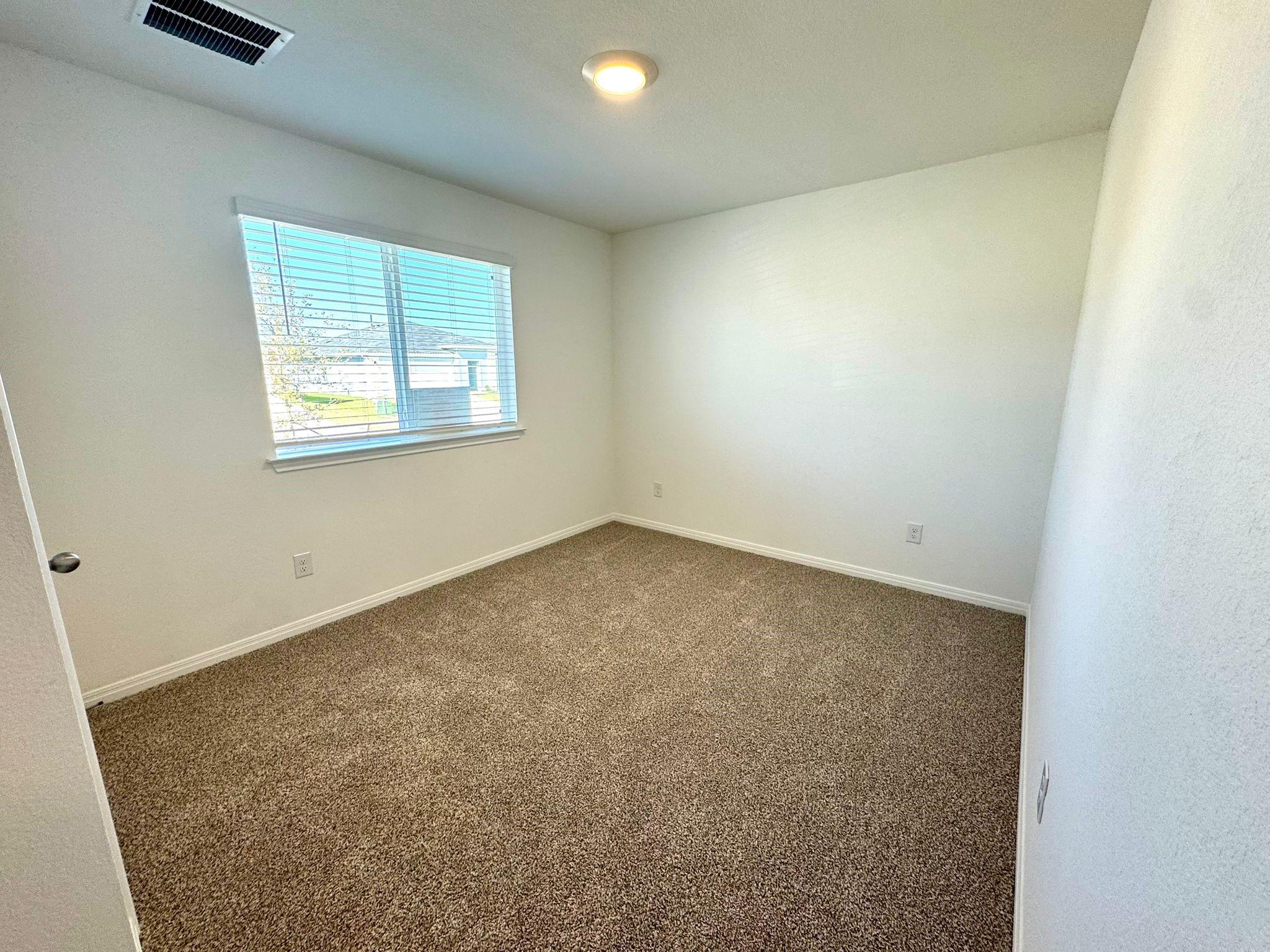 346 Gladiola Loop Kyle, TX 78640 - Photo 7 of 16 Spare room featuring dark colored carpet and baseboards