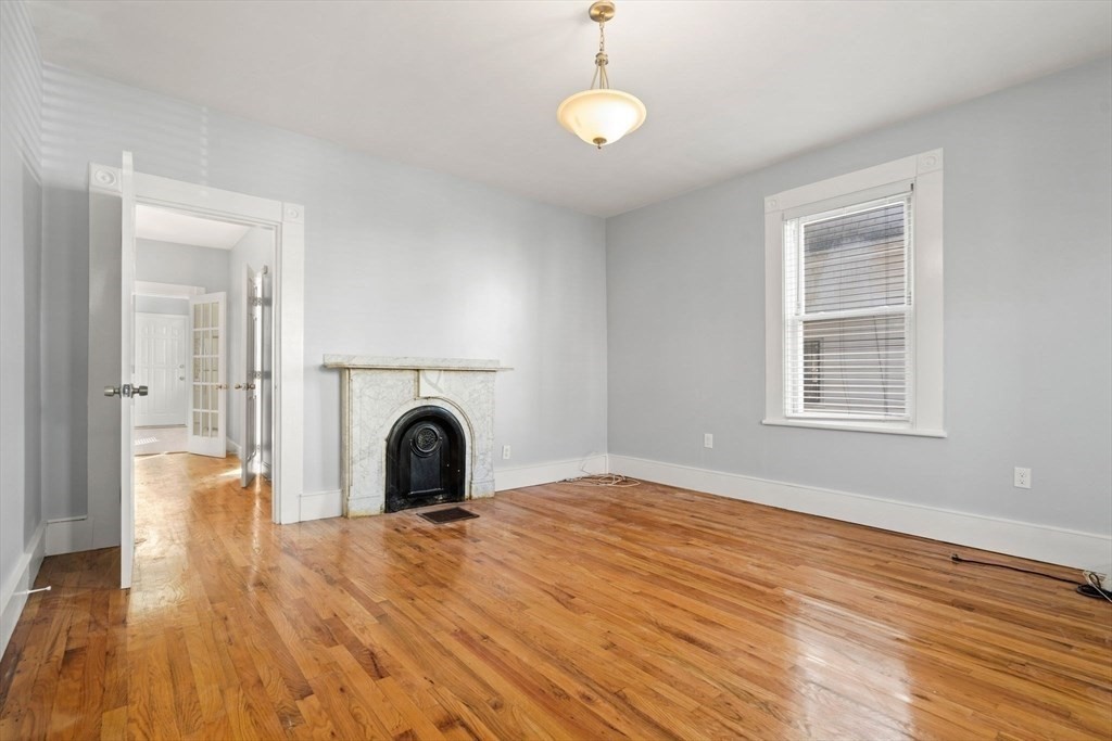 8 North Avenue, Unit 1 Boston, MA 02119 - Photo 5 of 15 a view of a livingroom with a fireplace and wooden floor