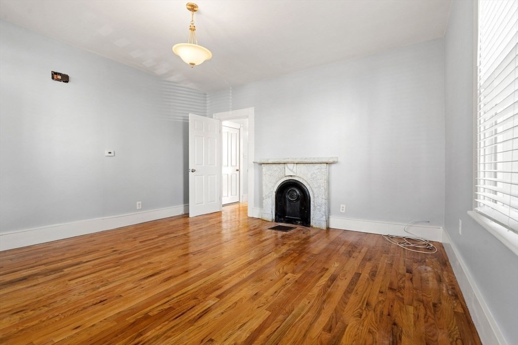 8 North Avenue, Unit 1 Boston, MA 02119 - Photo 6 of 15 wooden floor in an empty room with a window