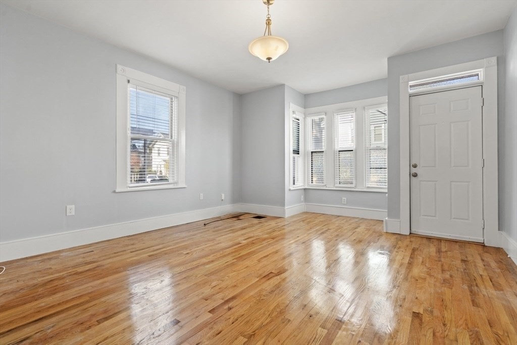 8 North Avenue, Unit 1 Boston, MA 02119 - Photo 8 of 15 a view of an empty room with wooden floor and fan