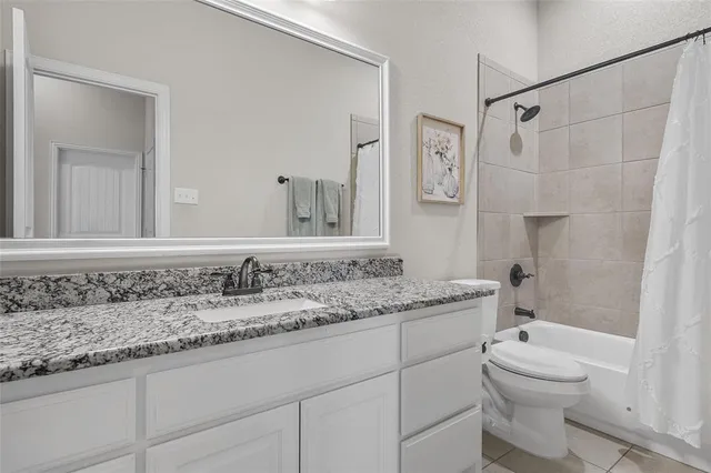 a bathroom with a granite countertop sink a toilet and a bathtub