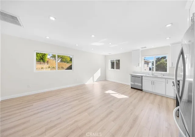 a view of a kitchen with furniture and wooden floor
