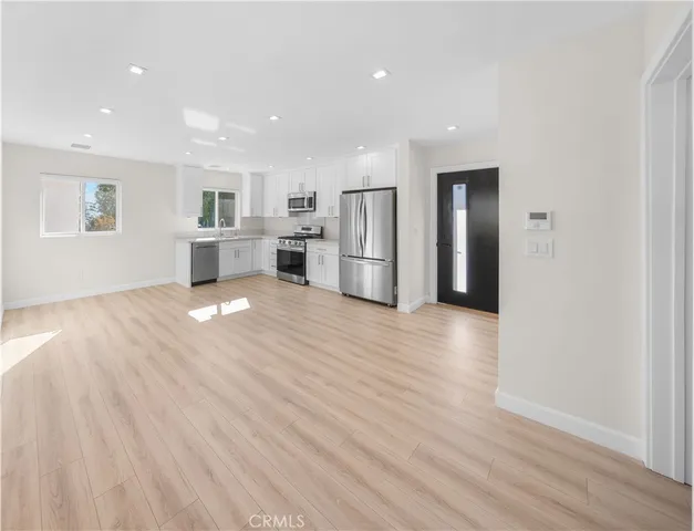 a view of a kitchen with wooden floor and electronic appliances