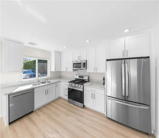 a kitchen with a sink stainless steel appliances and window