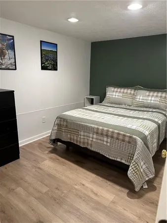 a bedroom with a bed and a black wall painting