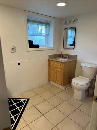 a bathroom with a toilet sink and mirror