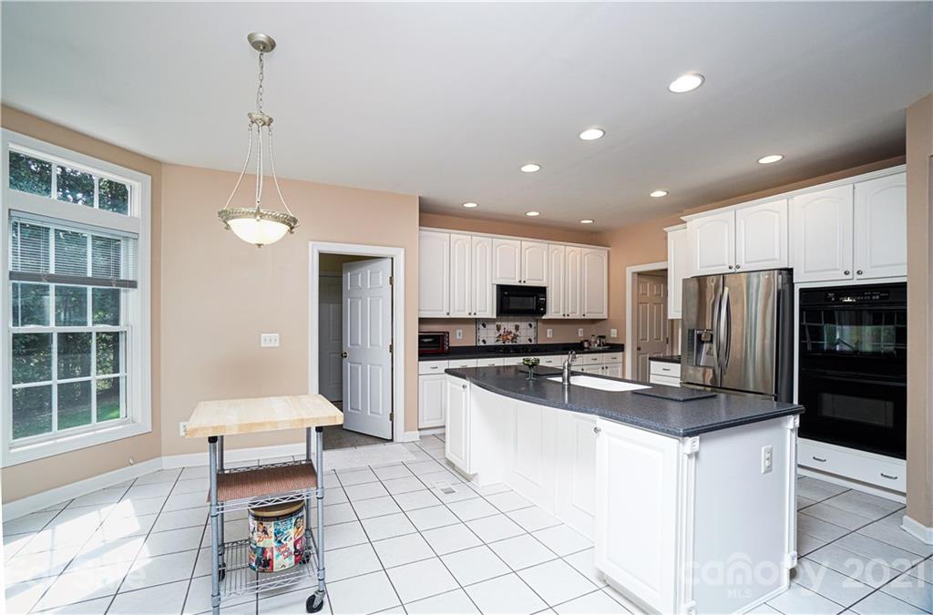 914 Chevis Court Fort Mill, SC 29708 - Photo 25 of 47 a kitchen with stainless steel appliances kitchen island granite countertop a refrigerator and a stove top oven