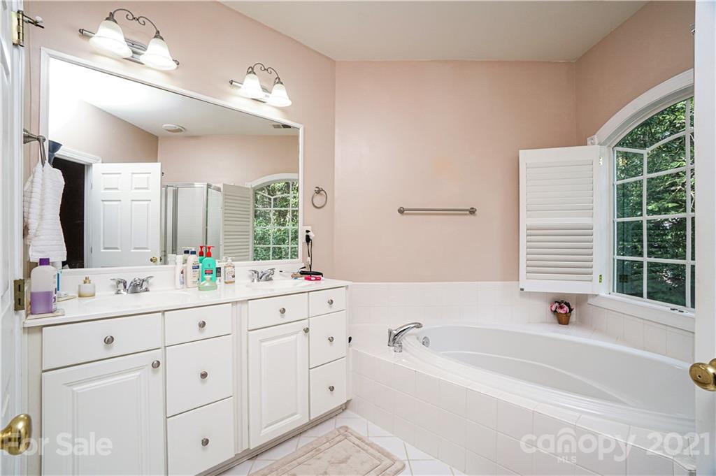 914 Chevis Court Fort Mill, SC 29708 - Photo 45 of 47 a bathroom with a bathtub a double vanity sink a vanity a window and a mirror