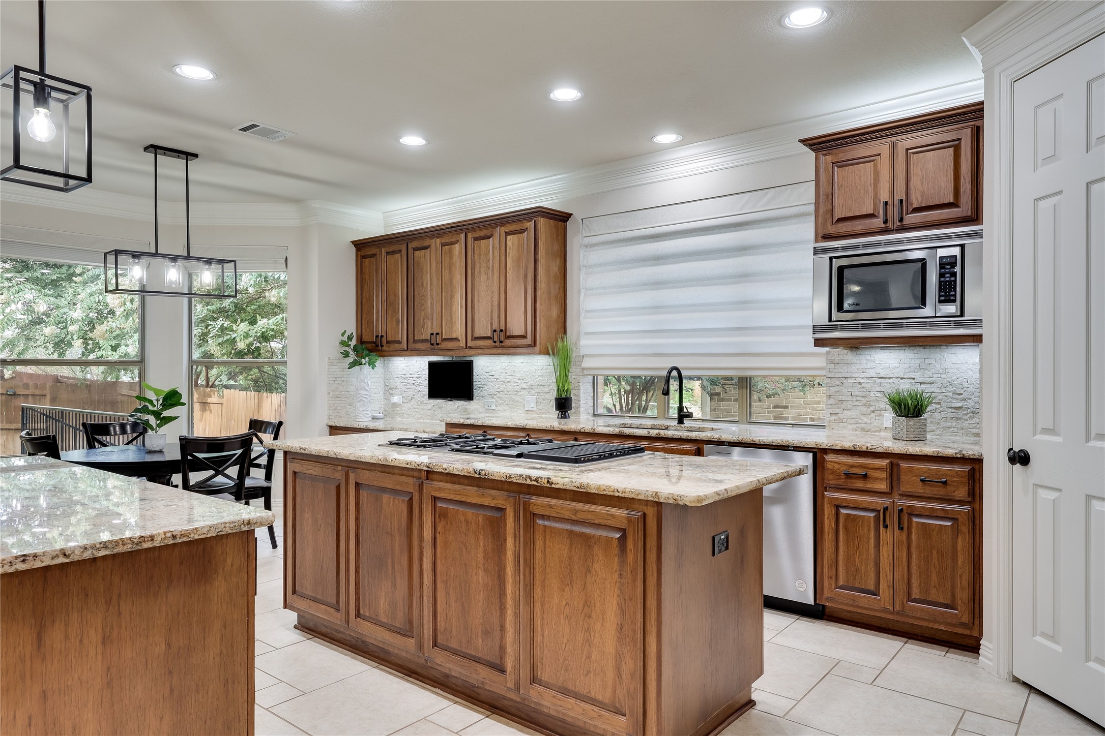 408 Ridgetop Bend Cedar Park, TX 78613 - Photo 12 of 40 A well-appointed kitchen features rich wood cabinetry and ample counter space, extending to an adjacent dining area.