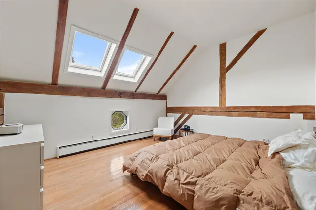 a bed sitting in a bedroom next to a window