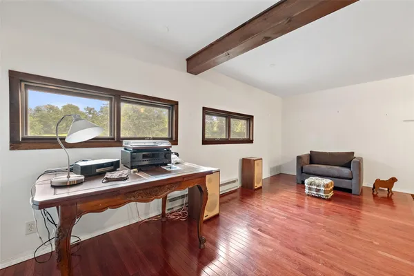 a work room with furniture wooden floor and windows