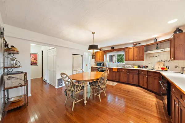 a kitchen with stainless steel appliances kitchen island granite countertop a table chairs and a refrigerator