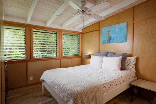 a bedroom with a bed and a painting on the wall