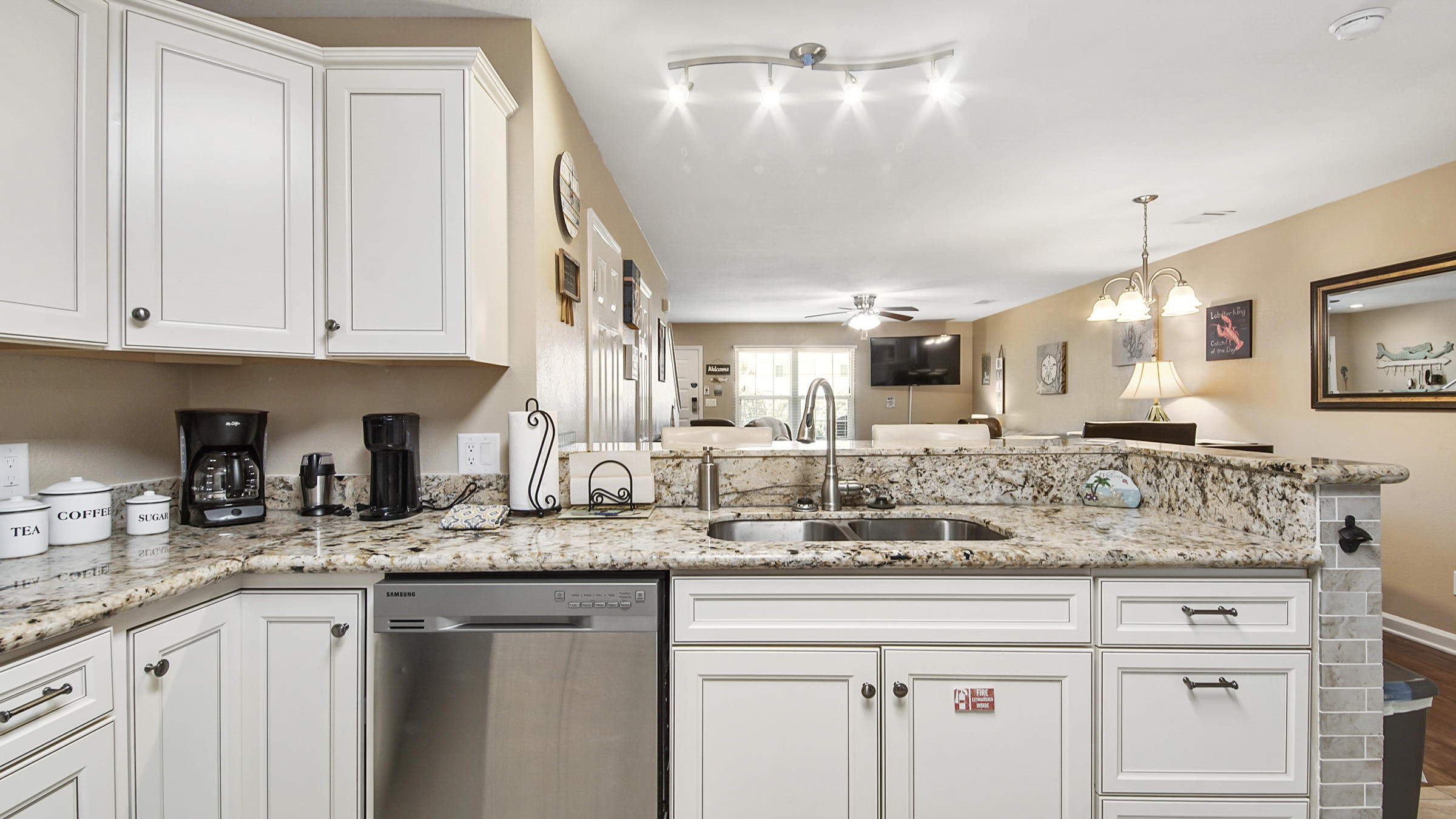 241 Ellis Road, Unit 51 Miramar Beach, FL 32550 - Photo 3 of 34 a kitchen with granite countertop a sink and white cabinets