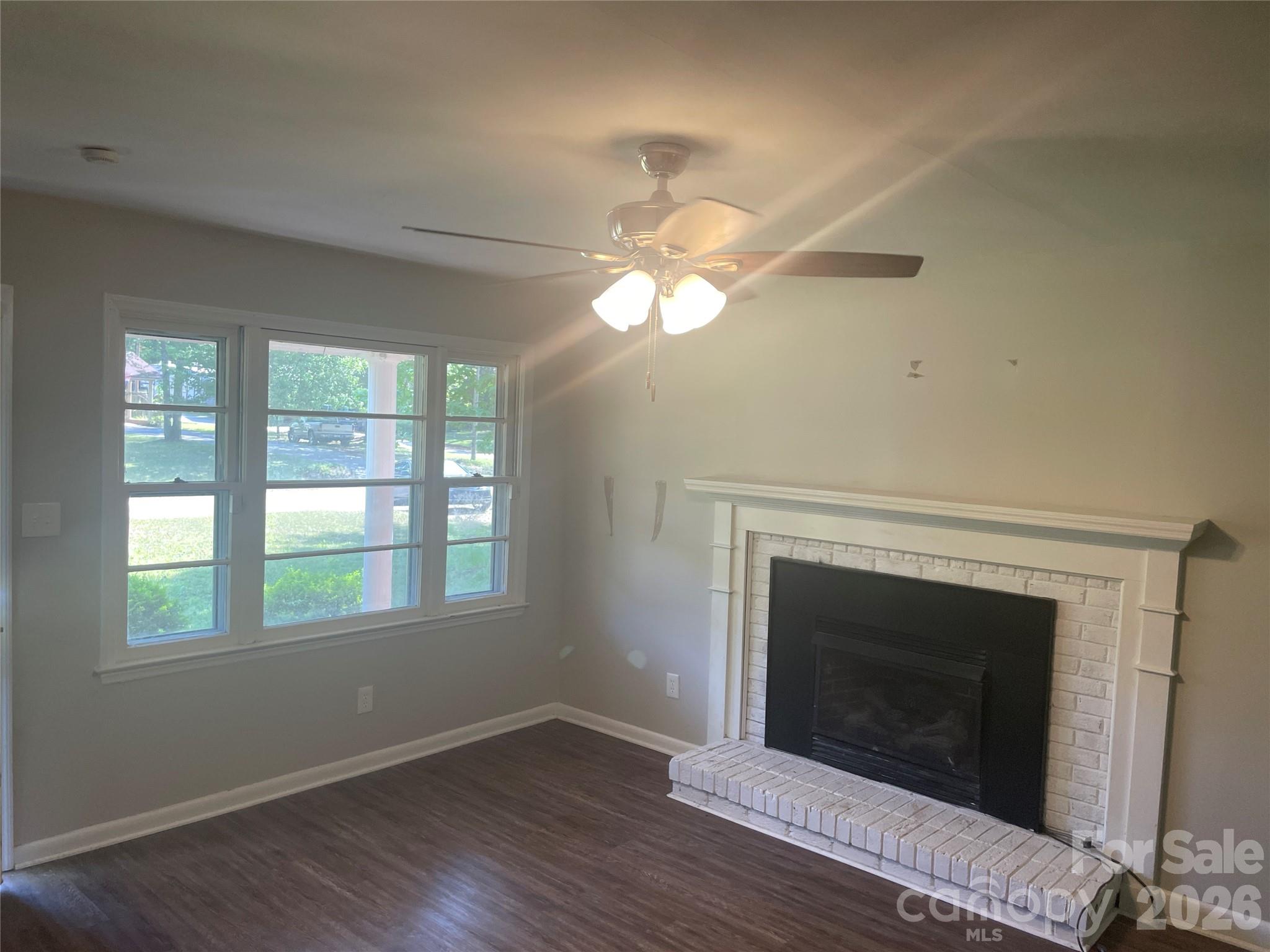 2801 Lyndell Way Lancaster, SC 29720 - Photo 3 of 10 a view of an empty room with wooden floor fireplace and a window