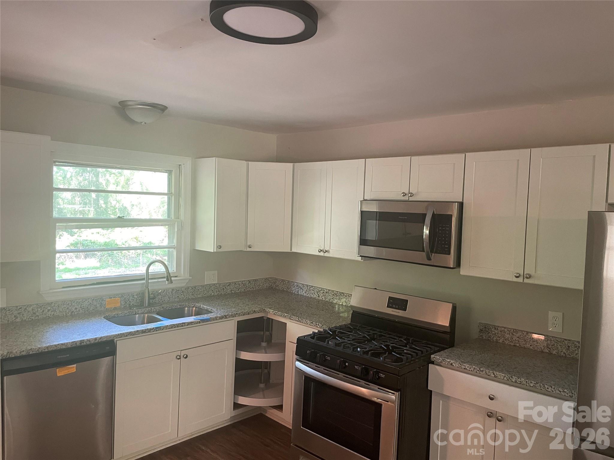 2801 Lyndell Way Lancaster, SC 29720 - Photo 4 of 10 a kitchen with granite countertop a sink cabinets stainless steel appliances and a window