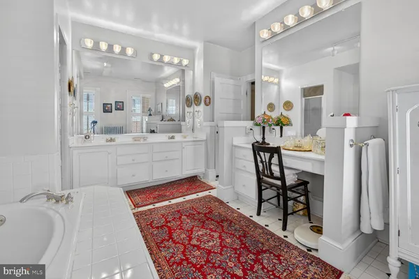 a bathroom with a double vanity sink mirror and bathtub