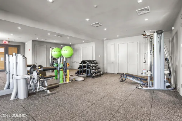 a view of a room with gym equipment and a large mirror