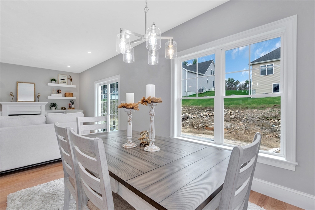 8 Weber Farm Road, Unit 8 Wrentham, MA 02093 - Photo 16 of 35 a dining room with wooden floor a chandelier a glass table and chairs