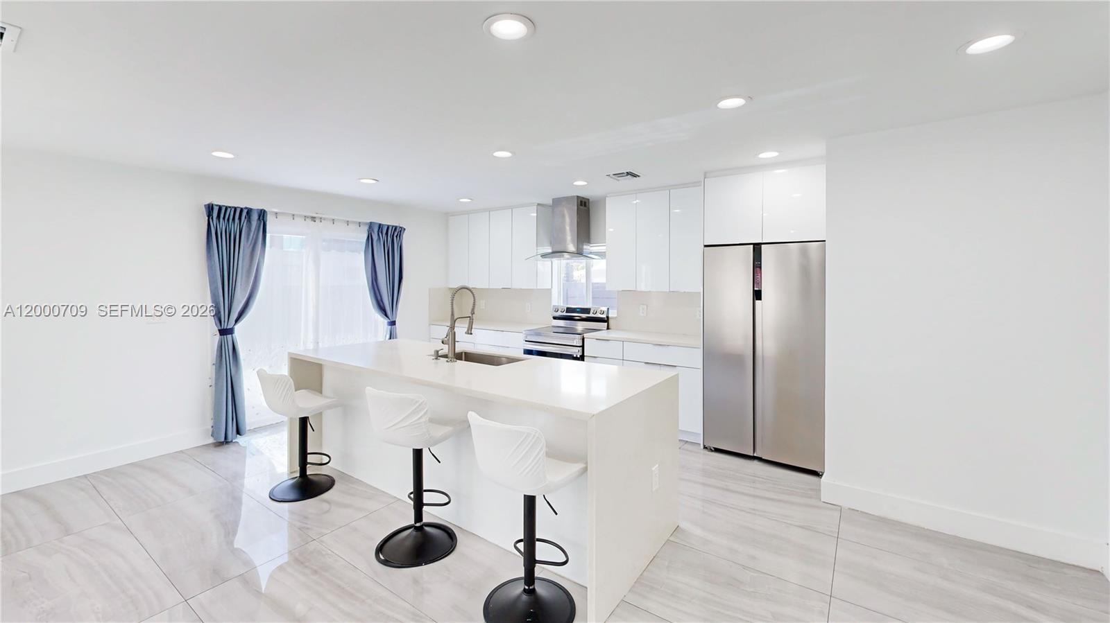 1886 Northwest 68th Street Miami, FL 33147 - Photo 13 of 56 a kitchen with stainless steel appliances kitchen island granite countertop a refrigerator a stove and white cabinets with wooden floor