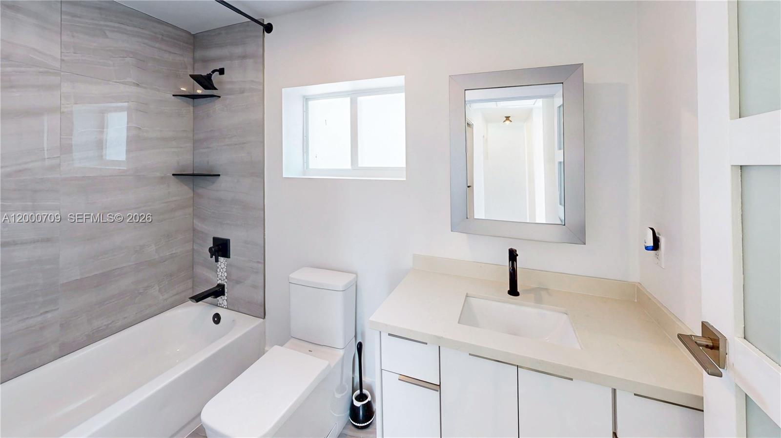 1886 Northwest 68th Street Miami, FL 33147 - Photo 30 of 56 a bathroom with a sink toilet vanity and bathtub