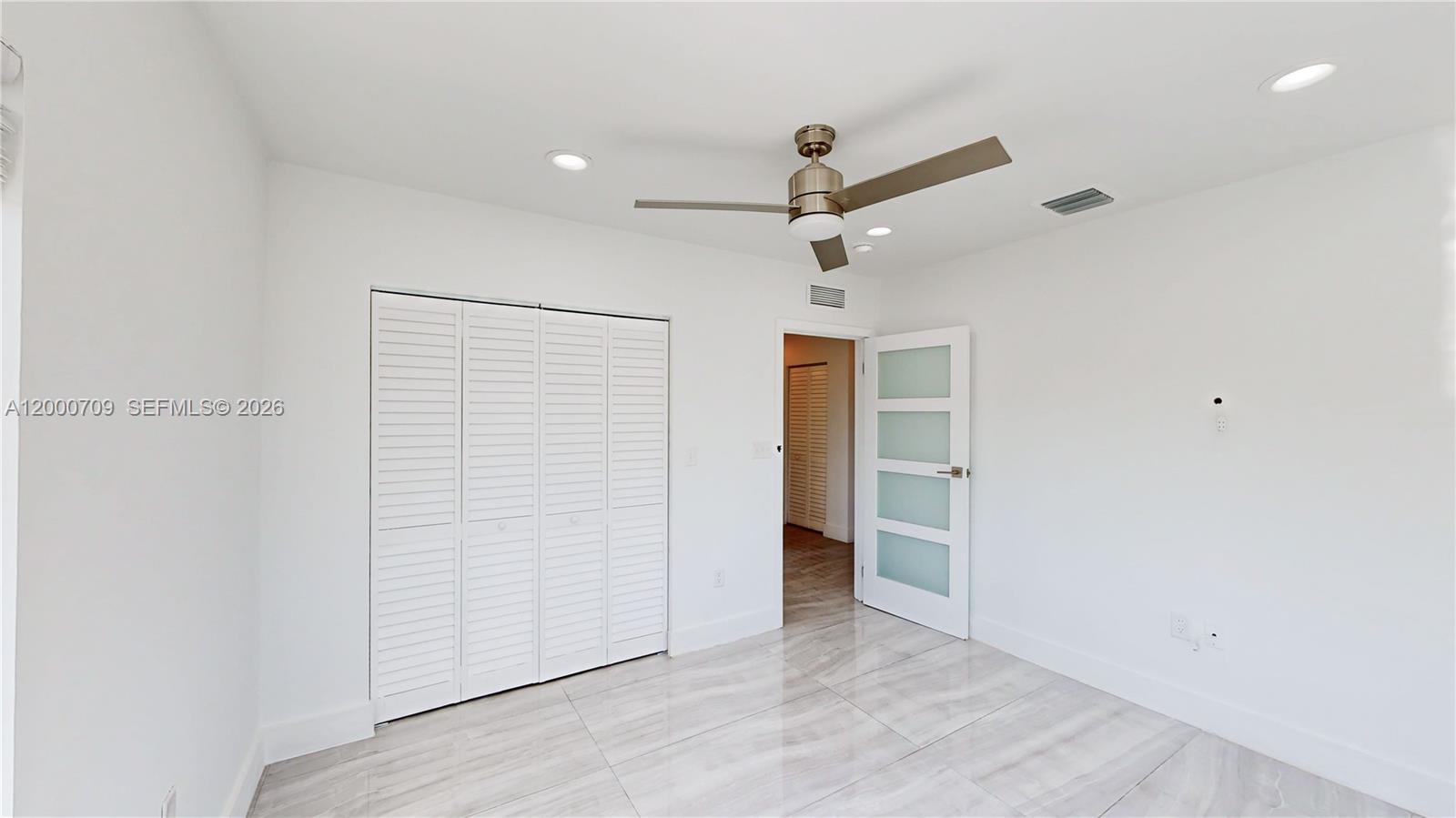 1886 Northwest 68th Street Miami, FL 33147 - Photo 34 of 56 an empty room with wooden floor and ceiling fan
