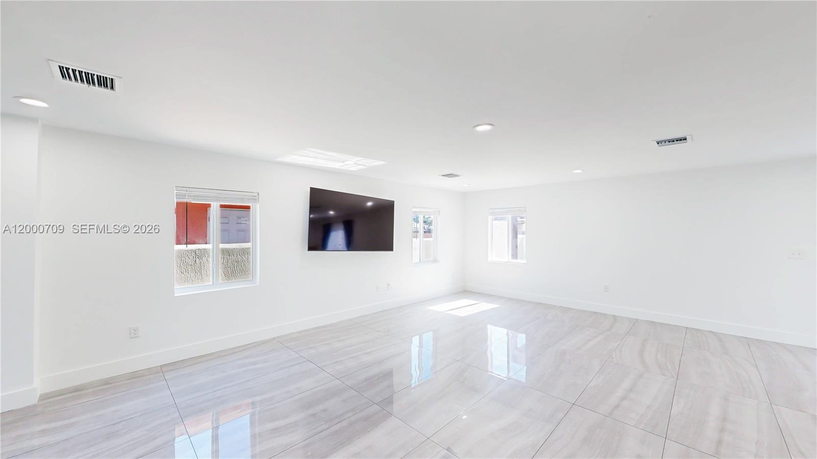 1886 Northwest 68th Street Miami, FL 33147 - Photo 6 of 56 a view of an empty room with wooden floor and a window