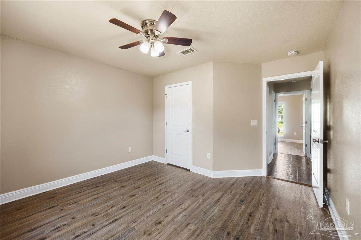 4015 Berry Circle Pace, FL 32571 - Photo 31 of 48 an empty room with wooden floor and a ceiling fan