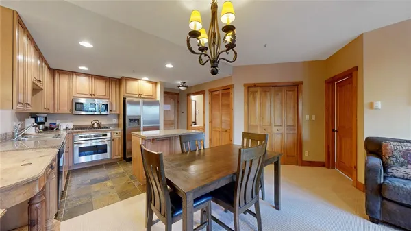 a kitchen with stainless steel appliances granite countertop a sink a stove a refrigerator cabinets and living room view